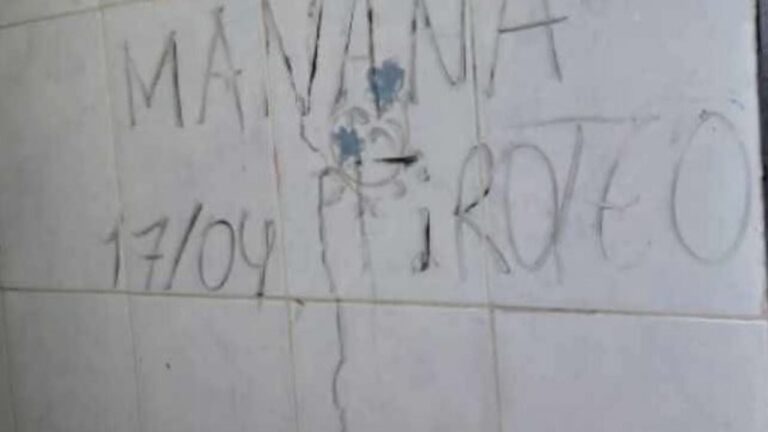Pared de sanitario escolar con grafiti amenazante en Catamarca