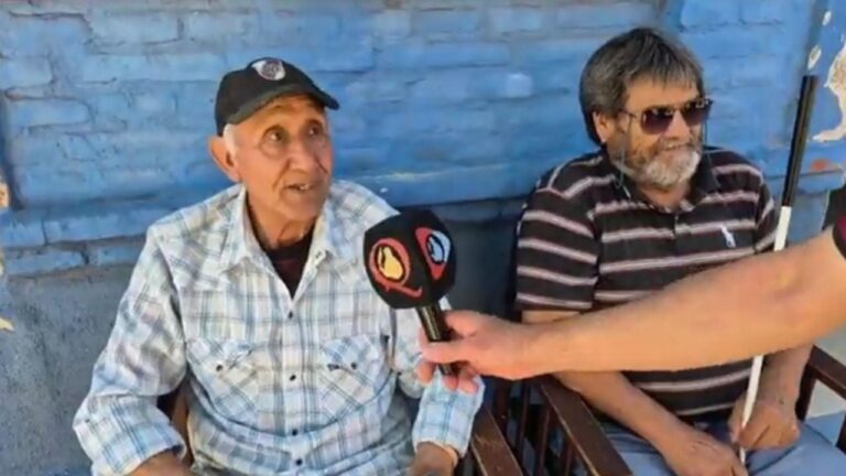 Personas caminando y conversando en la peatonal Rivadavia de Catamarca, con banderas de River y Boca al fondo.