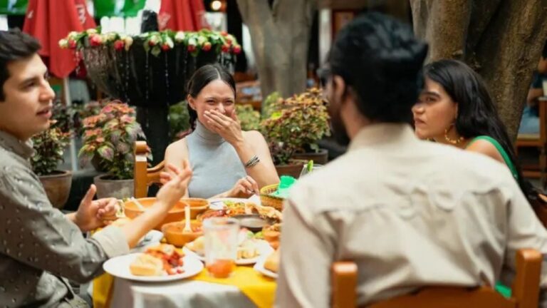 Personas compartiendo un asado y una pizza en una reunión familiar en casa