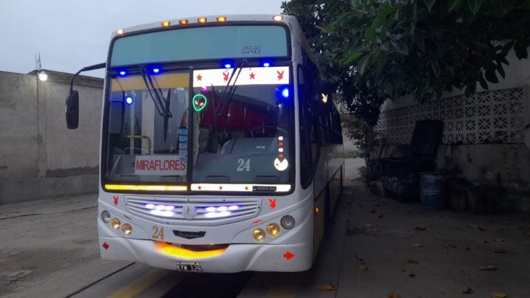 Estudiantes esperando transporte público en una parada al anochecer en Catamarca