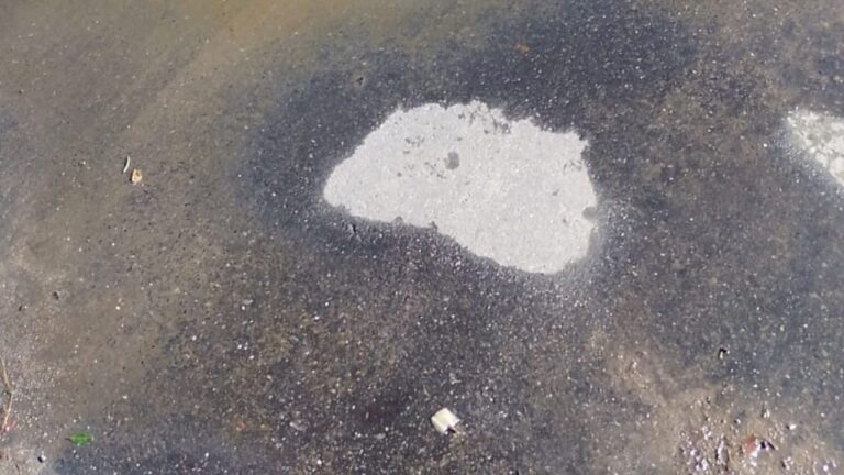 Ilustración de una calle con un posible bache o filtración de agua en el cordón, representando el reclamo en Maipú Norte.