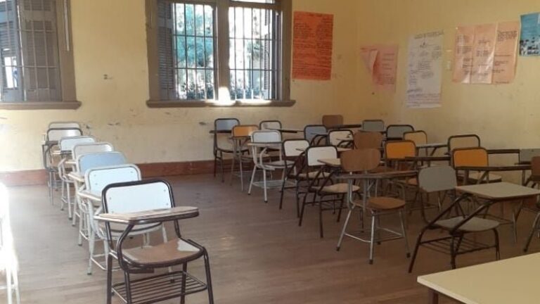 Docentes universitarios en asamblea con carteles de reclamo