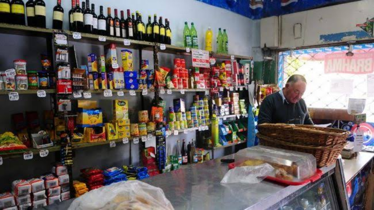 Almacén de barrio con estanterías y productos