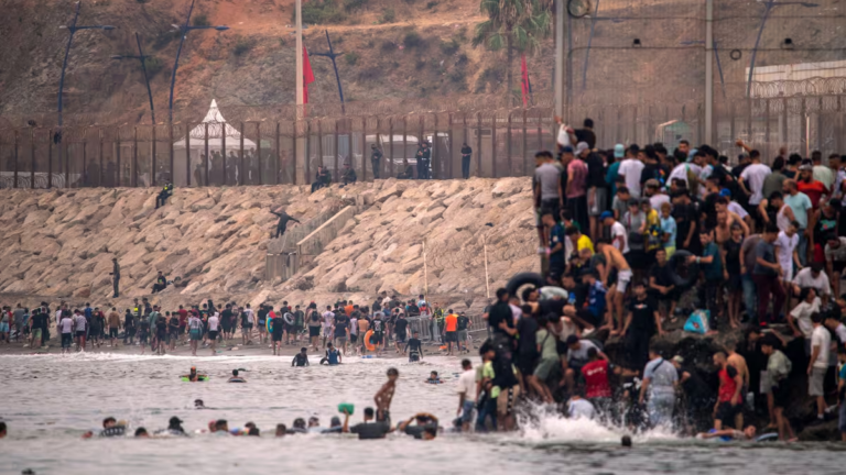 Migrantes en la frontera de Ceuta, algunos en el agua y otros en la playa