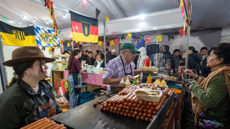 Stands del Paseo de los Inmigrantes en la Fiesta del Poncho con banderas y platos típicos de varios países