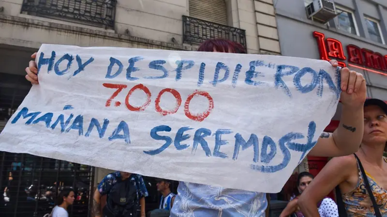 Personas en fila frente a una oficina de empleo