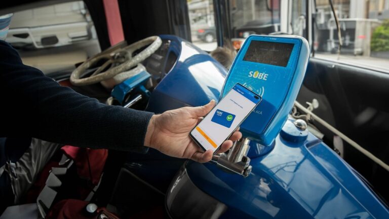 Persona usando tarjeta SUBE en un validador de colectivo