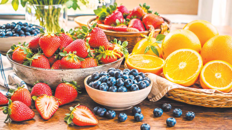 Frutillas, naranjas y arándanos sobre una mesa